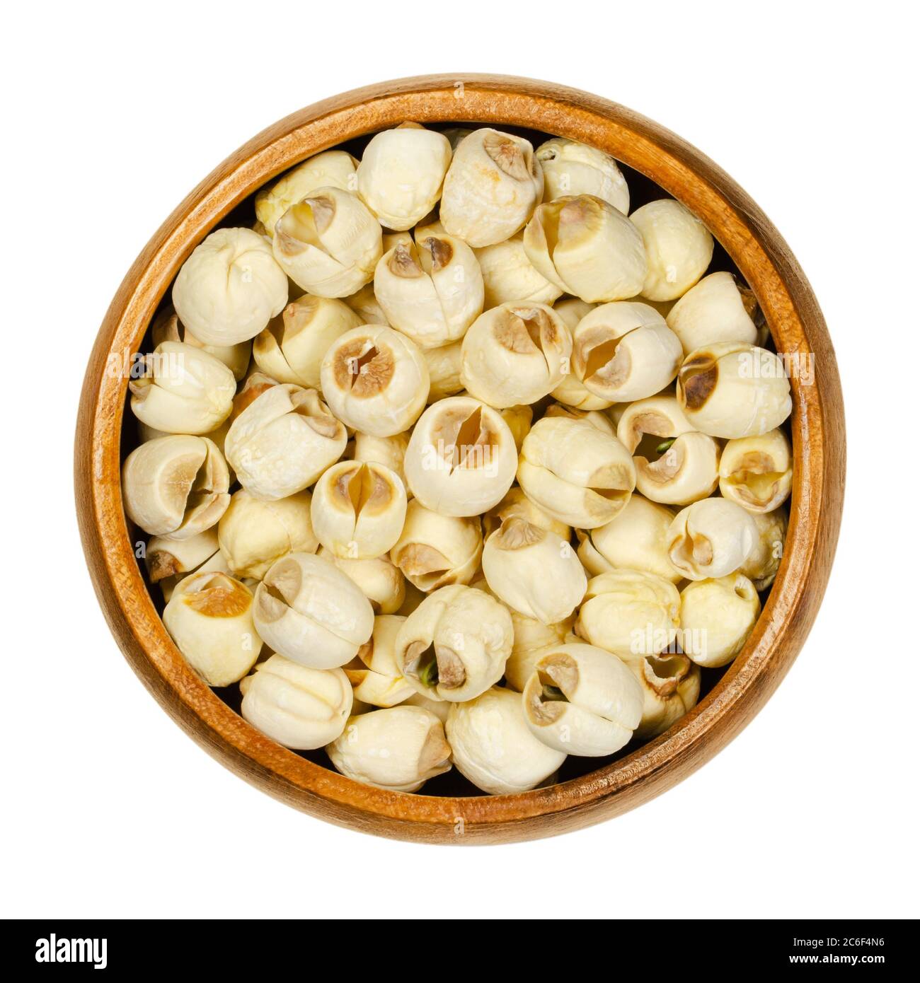 Frutta secca di loto sgusciata bianca in una ciotola di legno. Semi commestibili di loto indiano. Nelumbo nucifera, conosciuto anche come loto sacro, fagiolo dell'India. Foto Stock