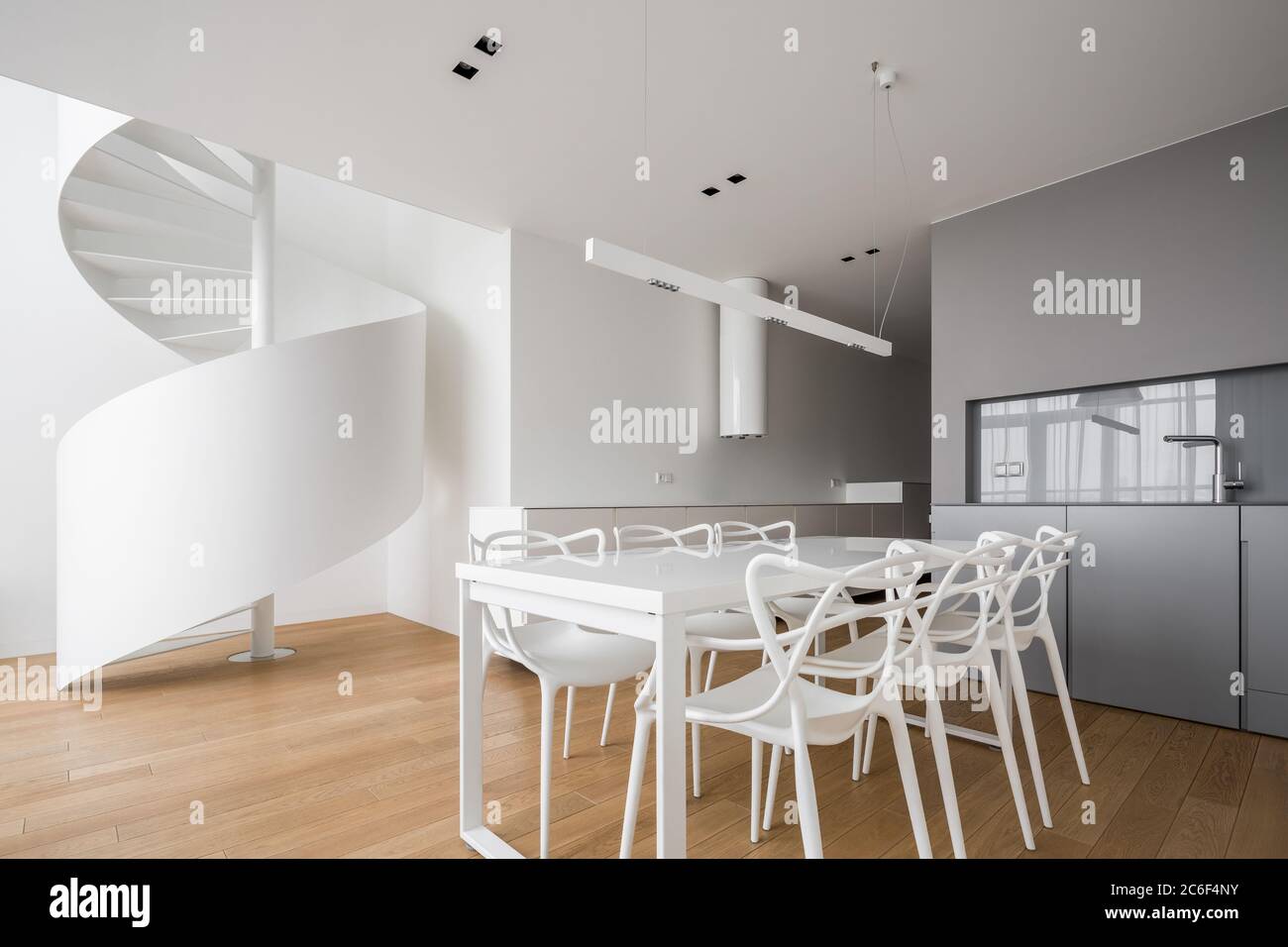 Nuovo design interno di casa e cucina aperta con tavolo da pranzo e una scalinata a spirale Foto Stock