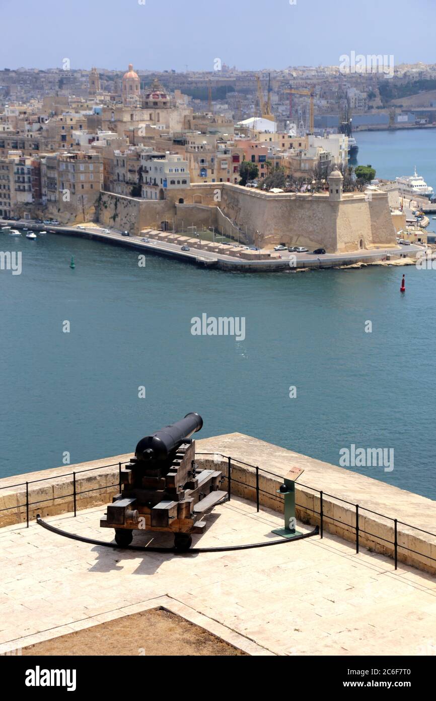 Valletta. Malta. Città vecchia. Una vista sul Porto Grande di Senglea con il Bastione di Spero alla fine della penisola. Il cannone a Saluting Battery. Foto Stock