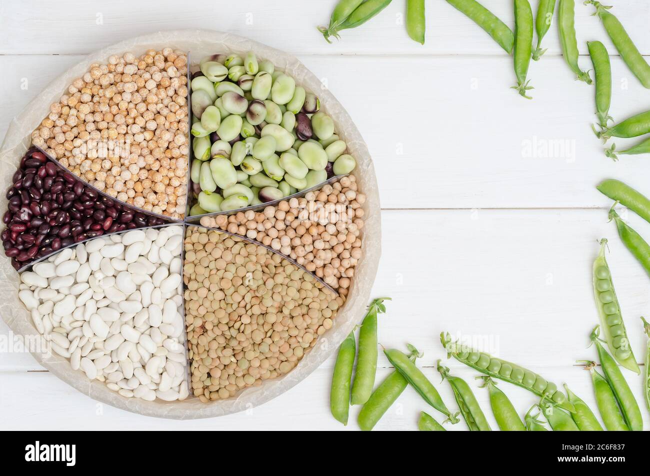 Fonte vegetariana di proteine. Fagioli, lenticchie, piselli, ceci, legumi. Vista dall'alto su una tabella bianca con spazio per la copia. Cibo sano. Foto Stock