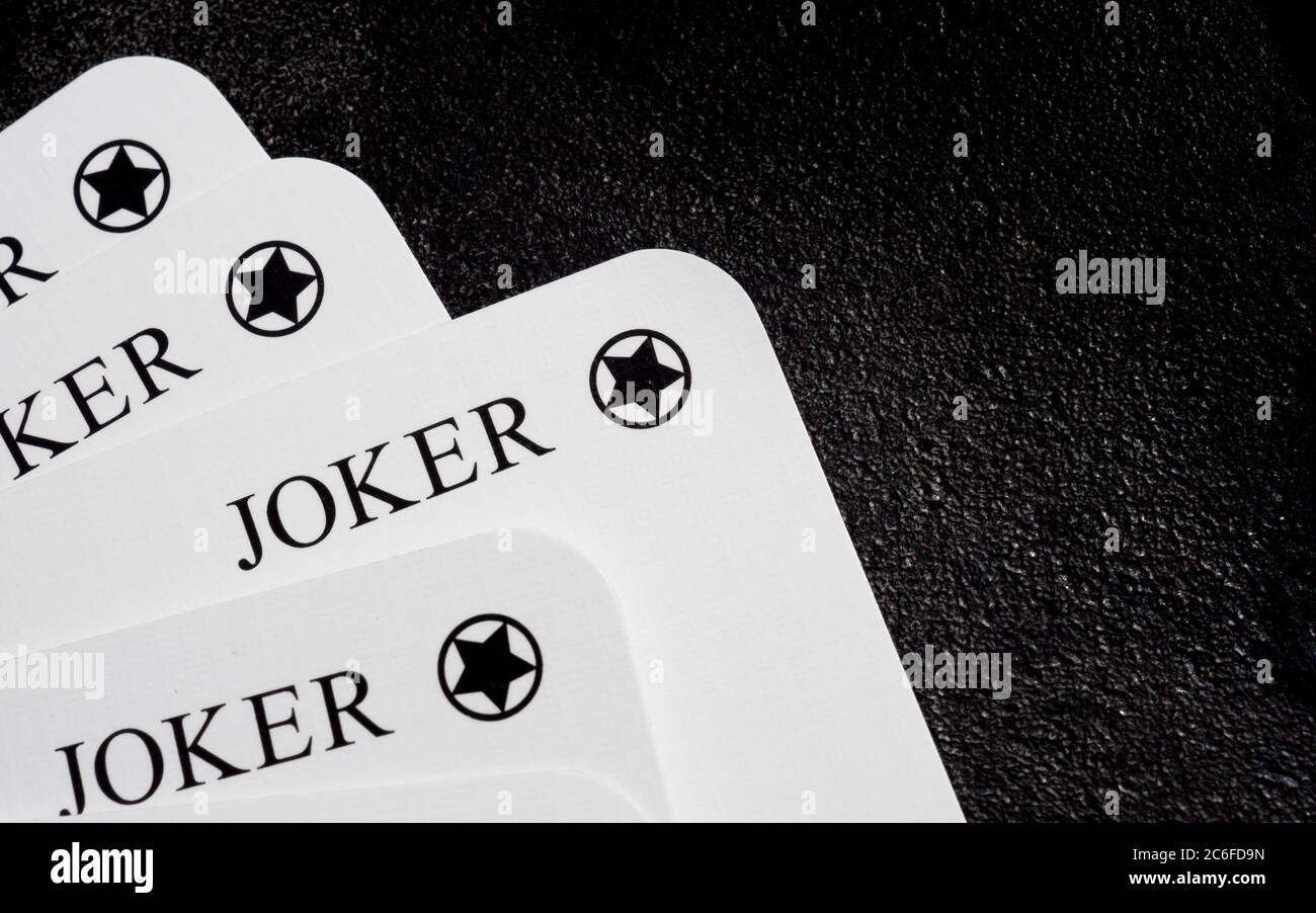 quattro carte da gioco bianche con una carta estratta dal mazzo nell'angolo inferiore sinistro sulla superficie in ghisa nera con spazio per la copia sul lato destro Foto Stock