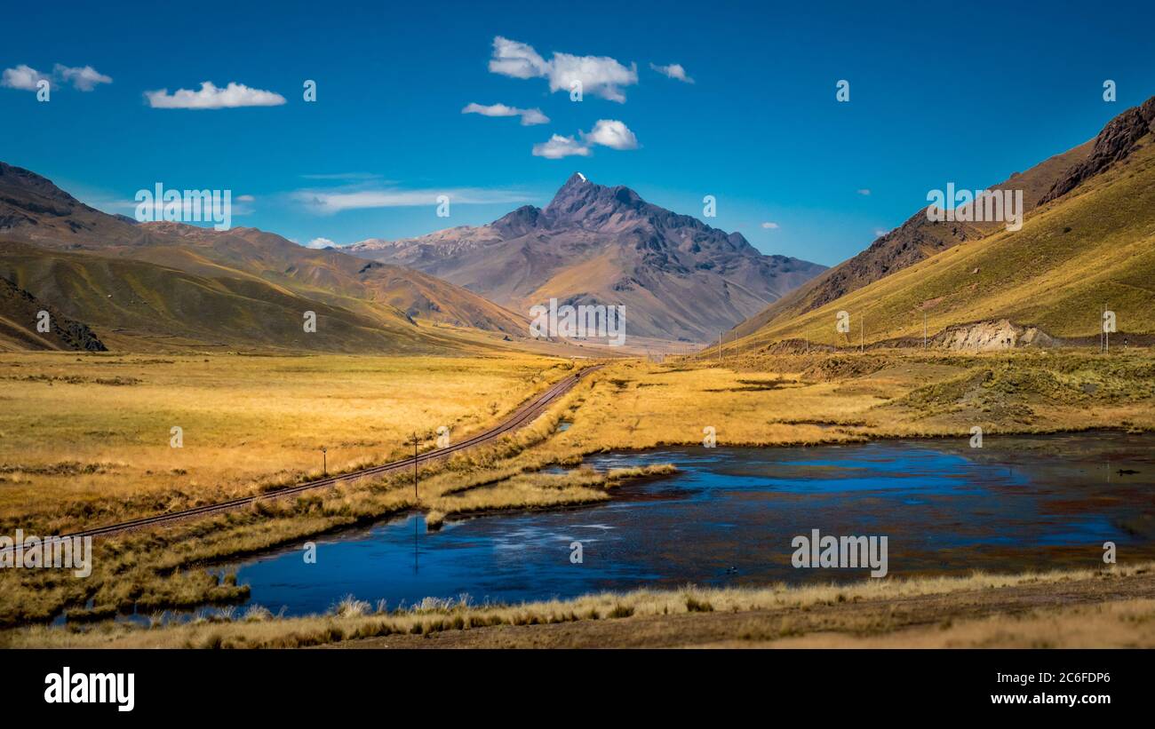 pianura highland in perù con binari ferroviari, montagna e lago Foto Stock