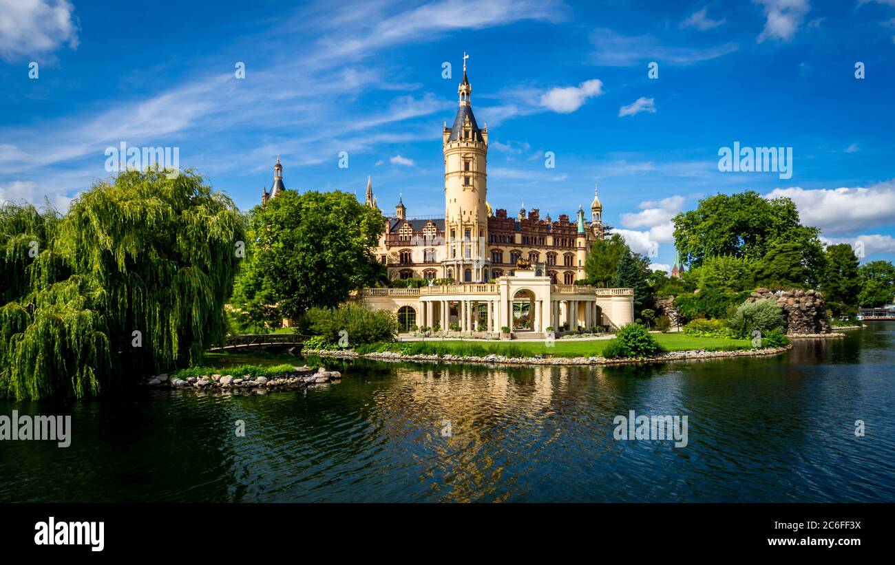 vista sul lago del famoso castello di schwerin la sede dell'ufficio regionale del governo nel meclemburgo-pomerania occidentale, di fronte al cielo blu con le nuvole Foto Stock