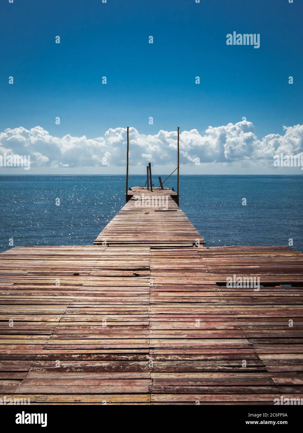 il palco di atterraggio perso con tavole stagne raggiunge direttamente il mare blu marino dei caraibi Foto Stock