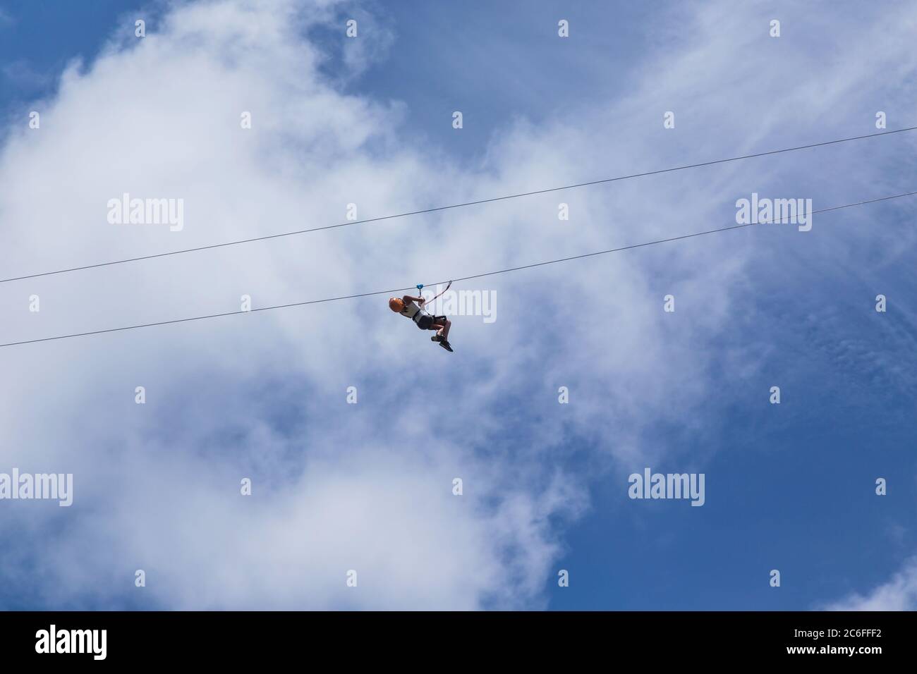 Monteverde, Costa Rica - 26 agosto 2019: Giovane donna avventurosa zip lining attraverso la foresta. Monteverde, Costa Rica. Foto Stock