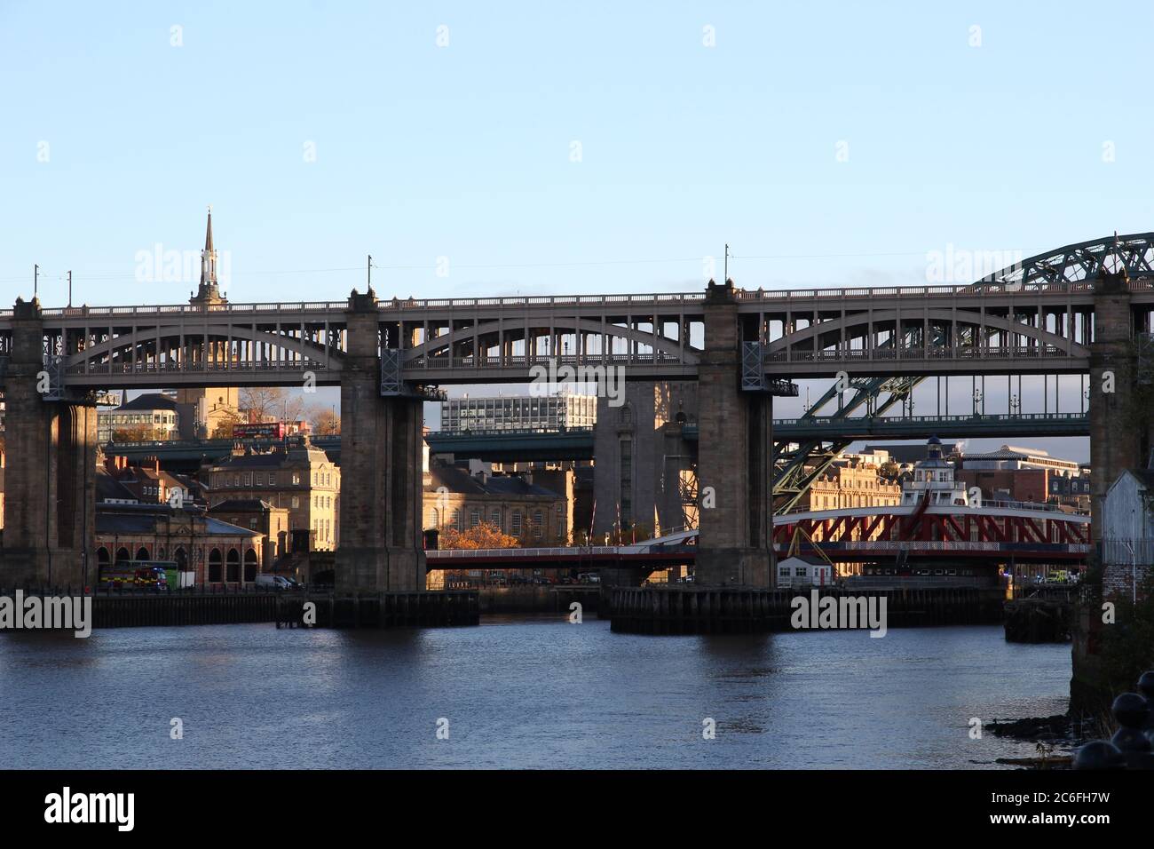 Il Newcastle-upon-Tyne High Level, Tyne e Swing Bridges si sono sizomati contro il Quayside, che è illuminato da un'Alba dorata Foto Stock