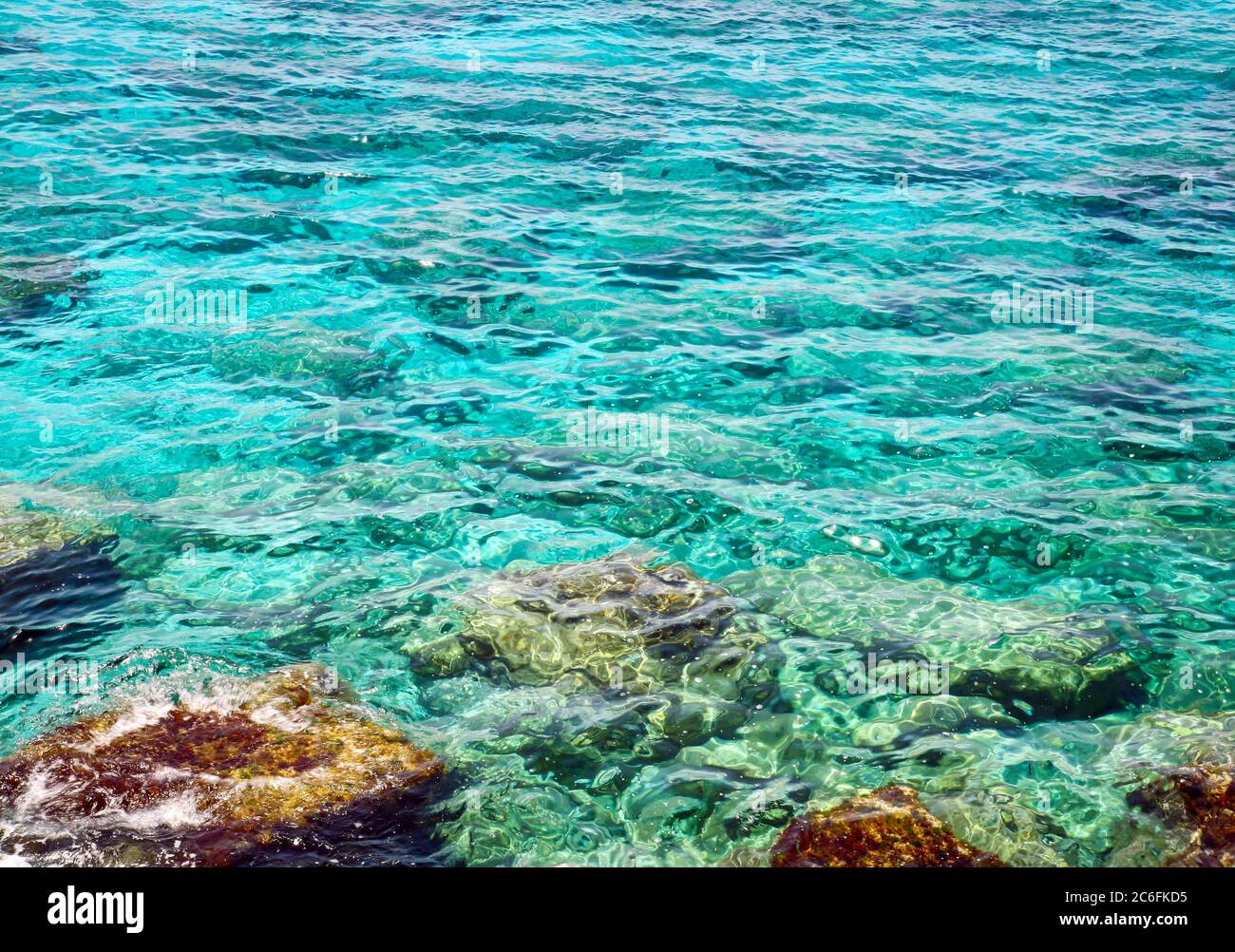 Mare turchese trasparente e pietre colorate nel Mar Mediterraneo a Cipro Foto Stock