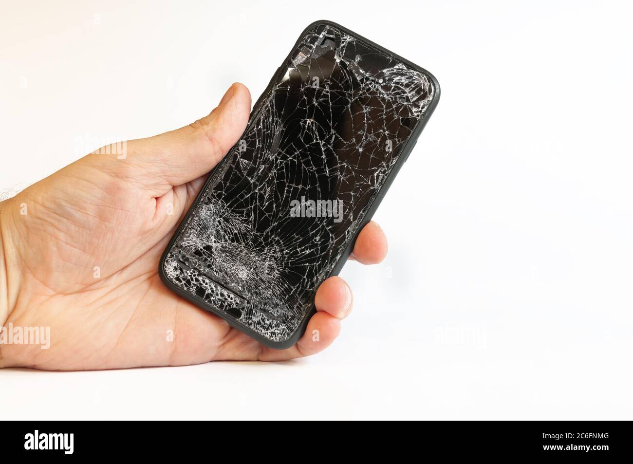 Smartphone moderno con schermo molto rotto in mano da uomo su sfondo bianco Foto Stock