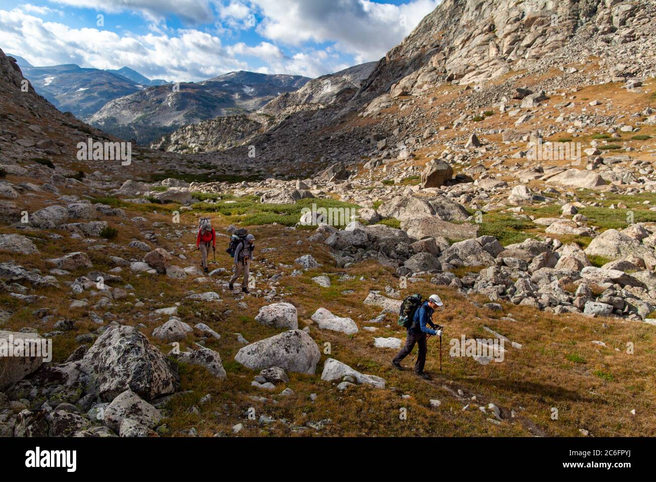 Tre backpackers maschi camminano attraverso la catena montuosa del fiume Vento nel Wyoming. Foto Stock