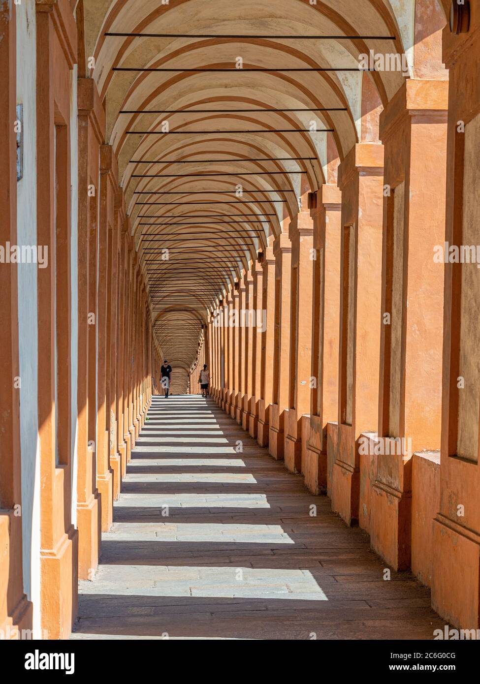 Il portico di San Luca, con due persone in lontananza. Bologna. Foto Stock