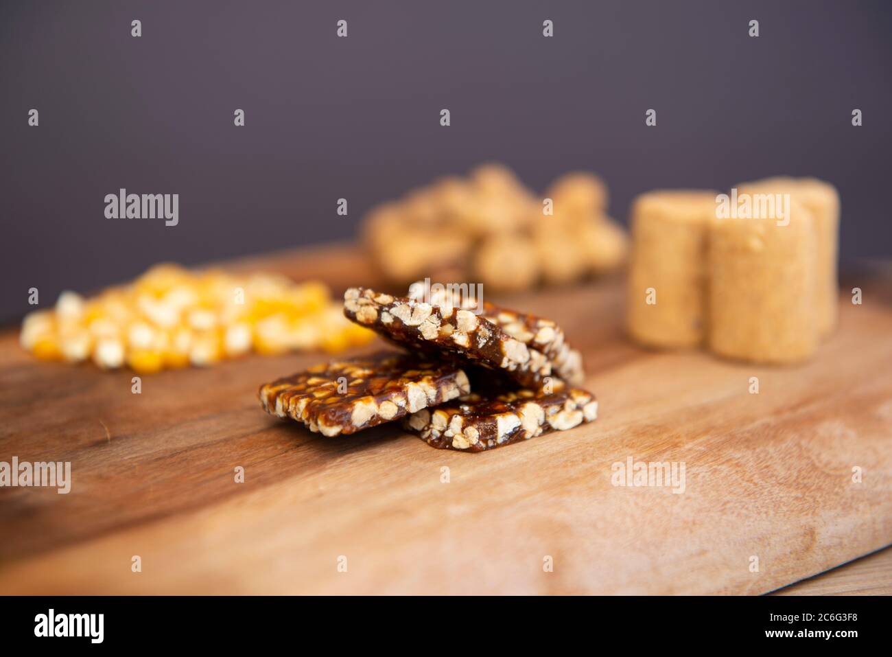 Tipici piatti brasiliani del Partito di giugno (Festa Junina) su un tavolo di legno: Arachidi caramelle (paçoca e pe-de-moleque), nocciole di mais, cialde di arachidi. Spazio di copia. Foto Stock