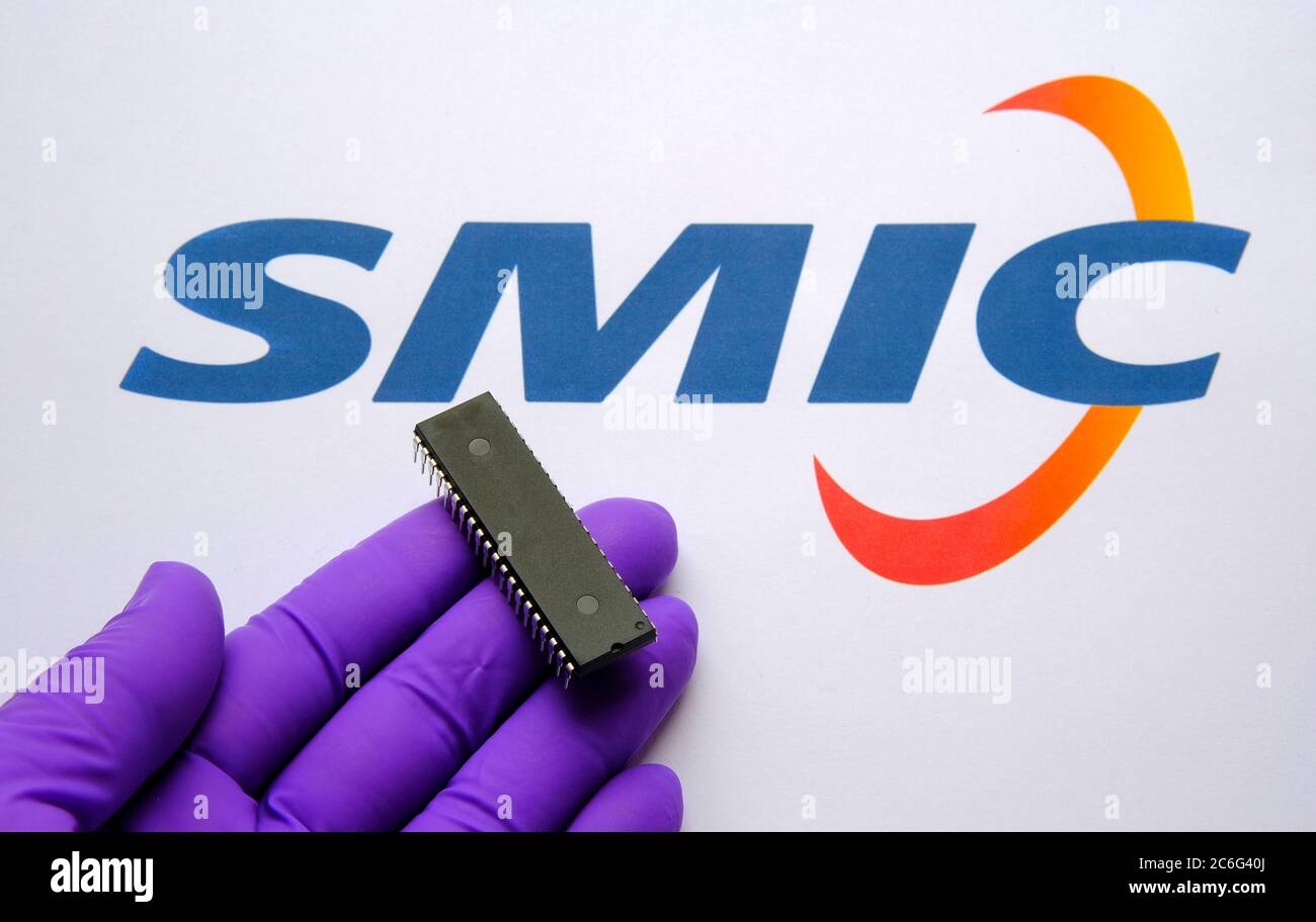 Stone / Regno Unito - 9 luglio 2020: Logo SMIC (Semiconductor Manufacturing International Corporation) sul documento stampato e un grande microchip Foto Stock