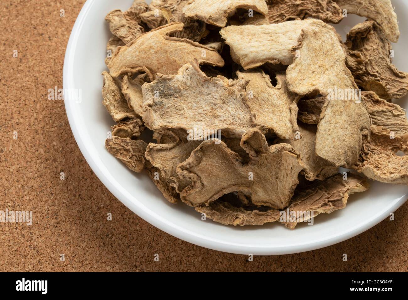 Radice di zenzero essiccata in un recipiente Foto Stock