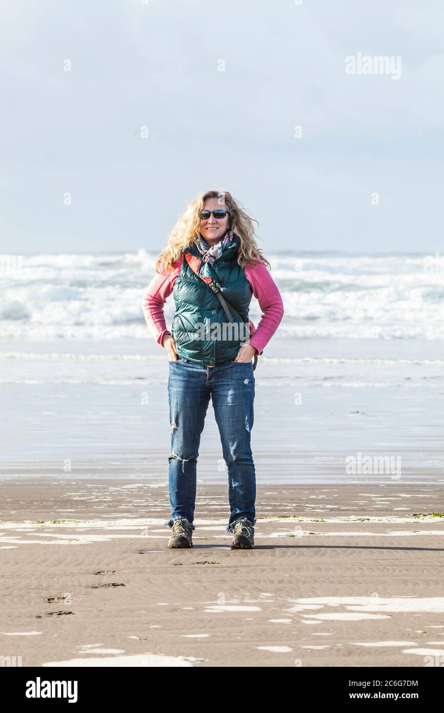 Una donna in piedi su una spiaggia. Pacific Coast, Seaside, Oregon, Stati Uniti. Foto Stock