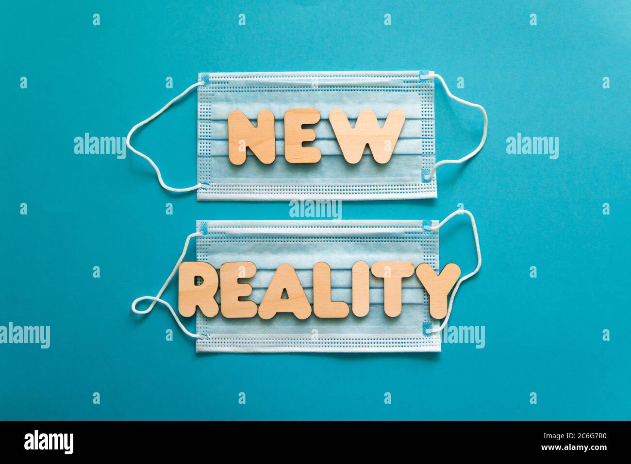 NUOVE parole DI REALTÀ sulle maschere facciali protettive su sfondo blu. Dopo covid-19 pandemie cambiamenti, nuova normale, indossare maschera viso in concetto pubblico. Foto Stock