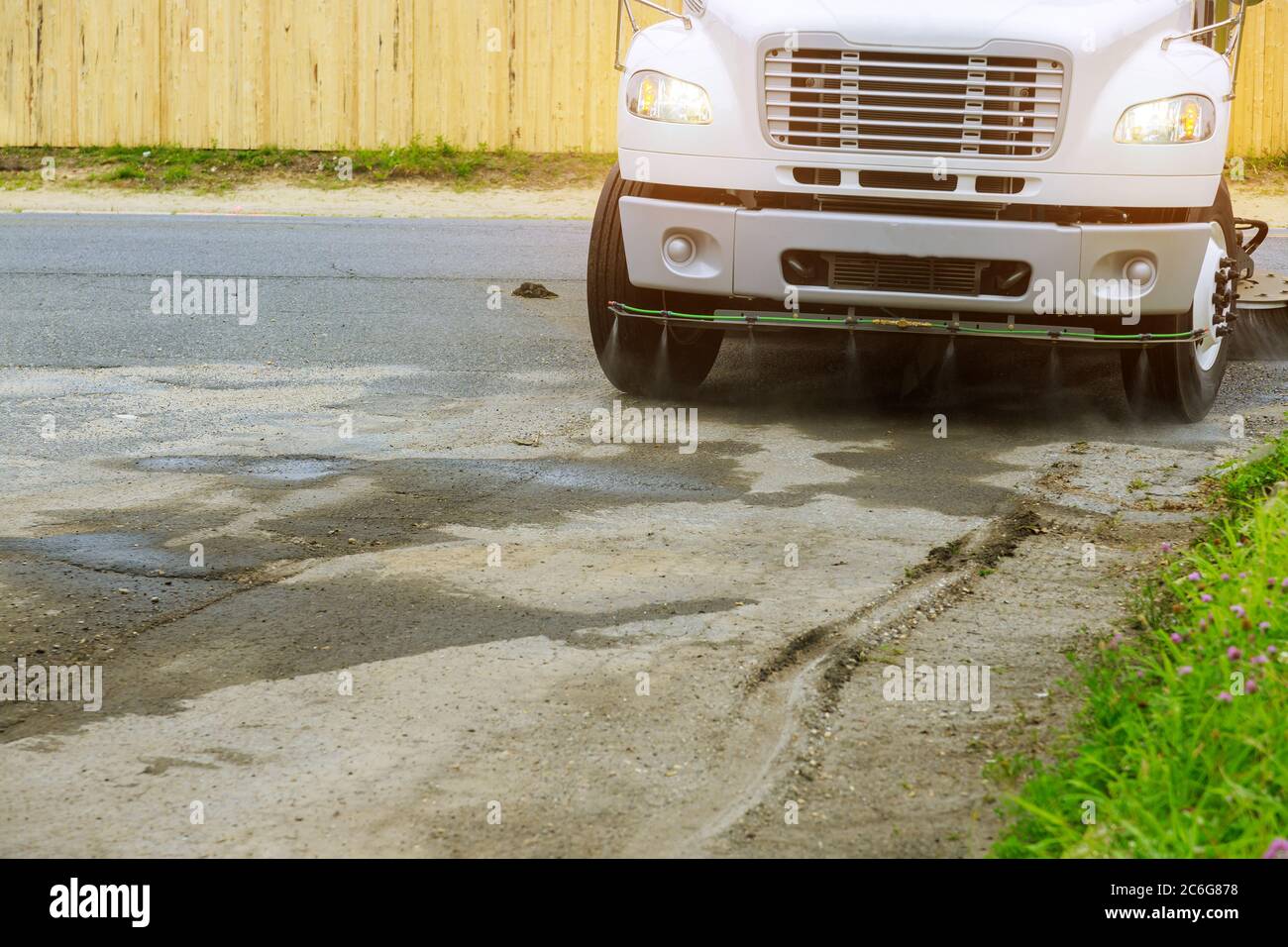 Pulizia macchine spazzatrici lavaggi asfalto strada con acqua spray sulla città. Foto Stock