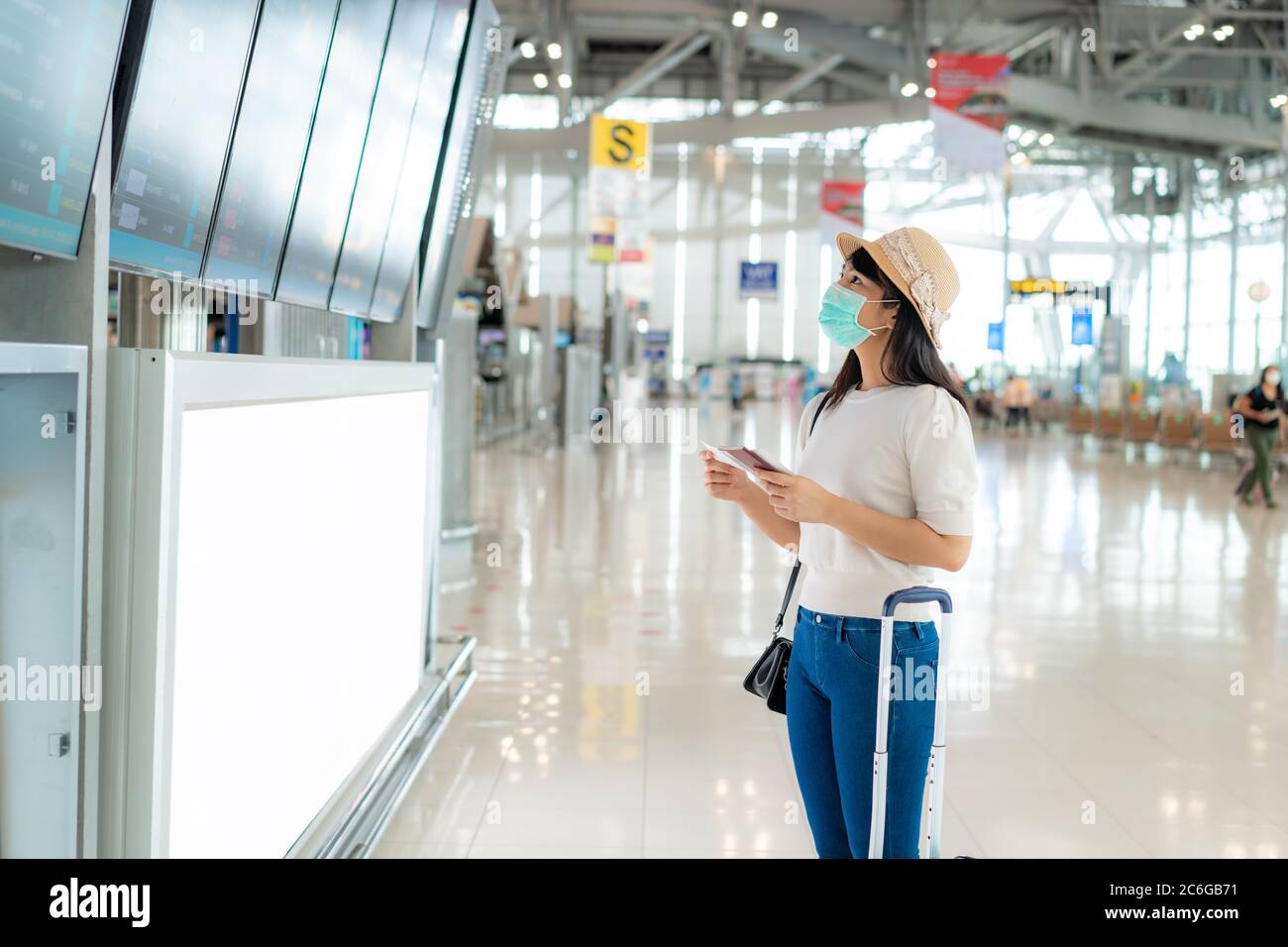 Donna asiatica turista indossare maschera di controllo volo dall'arrivo partenza bordo nel terminal aeroporto per nuovo concetto di viaggio normale. Foto Stock