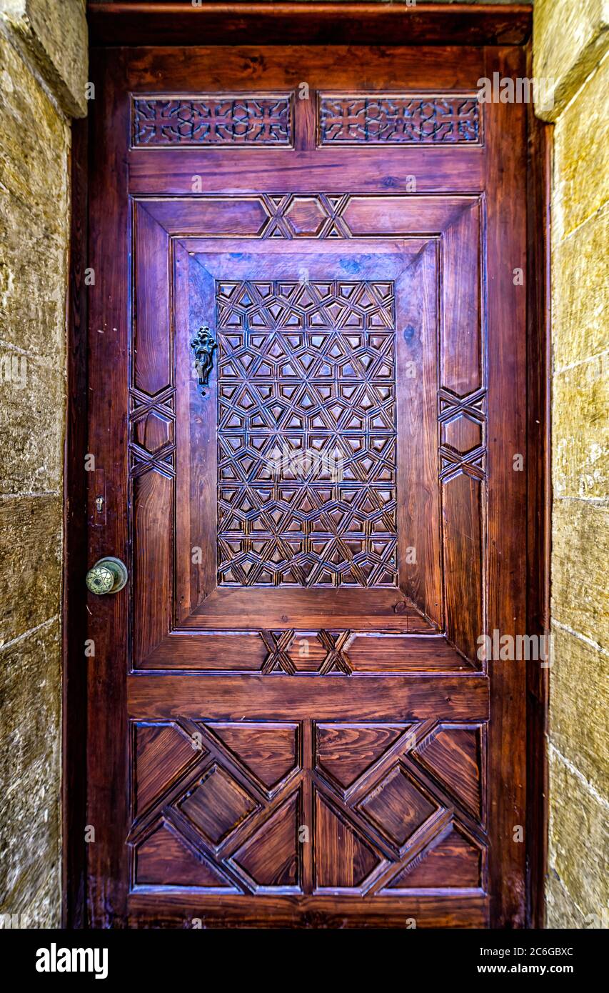 Motivi geometricamente sagomati scolpiti su una porta di legno duro presso la Chiesa di Hanging del Cairo copto Foto Stock