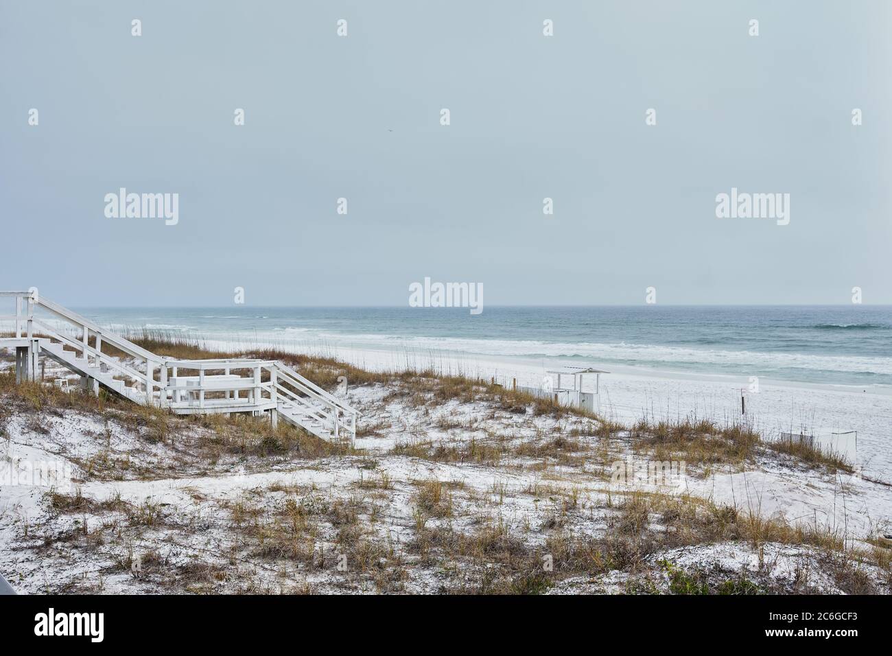 Bianco su bianco. La scalinata in legno sulle dune costiere di Destin, Florida, conduce alla luminosa spiaggia di sabbia bianca e alle acque verdi pallidi del Golfo del Messico. Foto Stock