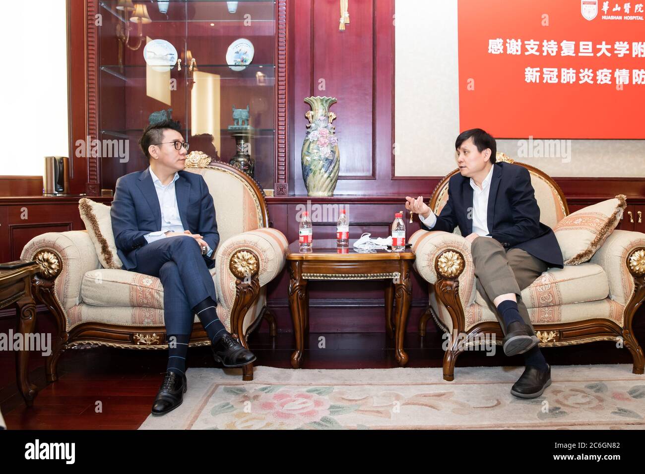 A nome della China Football Association, segretario principale della CFA Liu Yi, a sinistra, parla con il professor Zhang Wenhong dell'ospedale di Huashan, a destra, Shangha Foto Stock