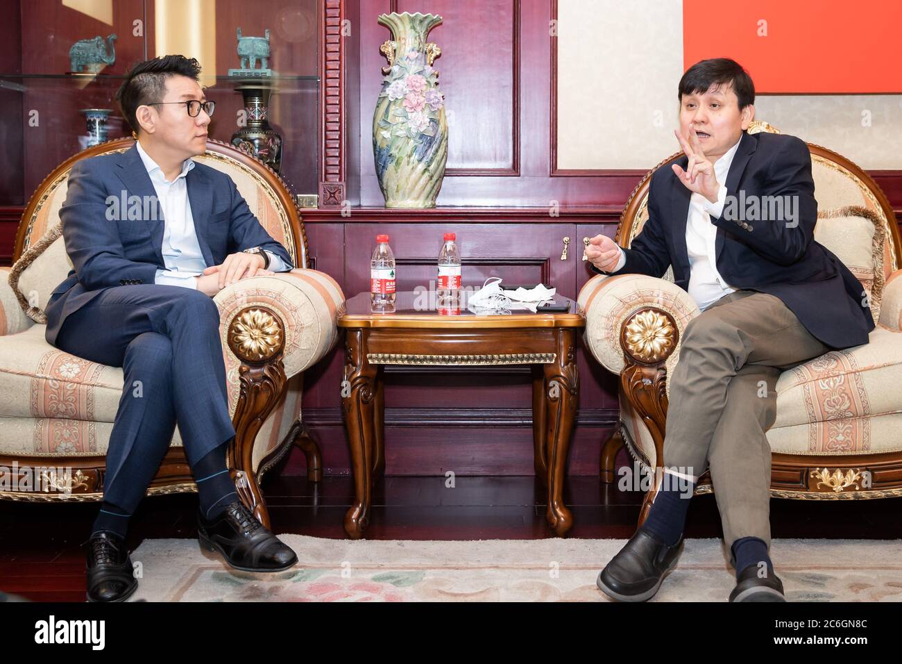 A nome della China Football Association, segretario principale della CFA Liu Yi, a sinistra, parla con il professor Zhang Wenhong dell'ospedale di Huashan, a destra, Shangha Foto Stock