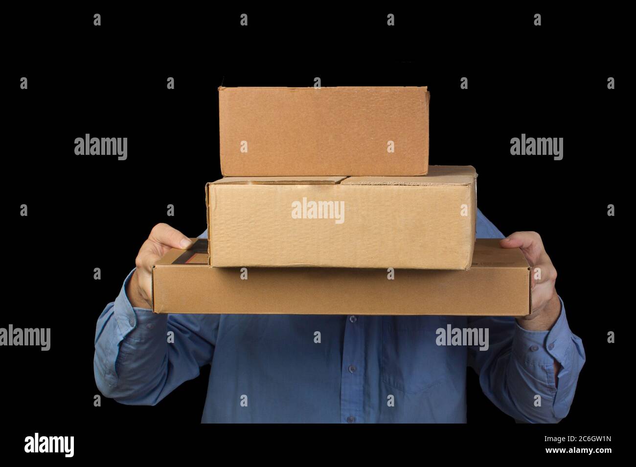 Uomo in camicia blu contiene tre scatole di cartone. Copre il suo volto. Consegna di merci da negozi online. Foto Stock