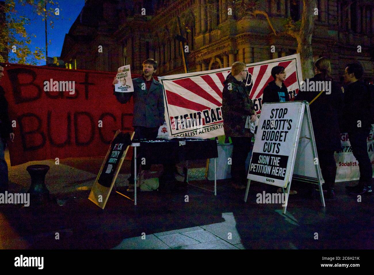 I manifestanti socialisti alternativi fuori dal Municipio di Sydney protestano contro le proposte di tagli al bilancio del partito liberale del primo ministro Tony Abbott. Foto Stock