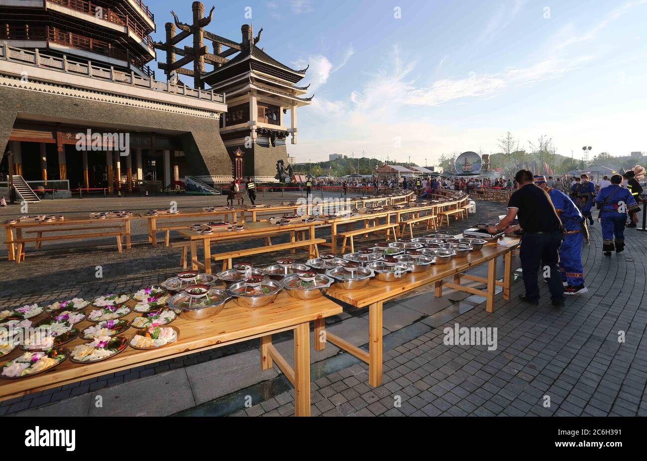 La gente locale di Miao ha trattato centinaia di turisti ad un banchetto tradizionale lungo-tavolo il lunedì durante un festival gourmet nel villaggio etnico di Duocai, Guiya Foto Stock