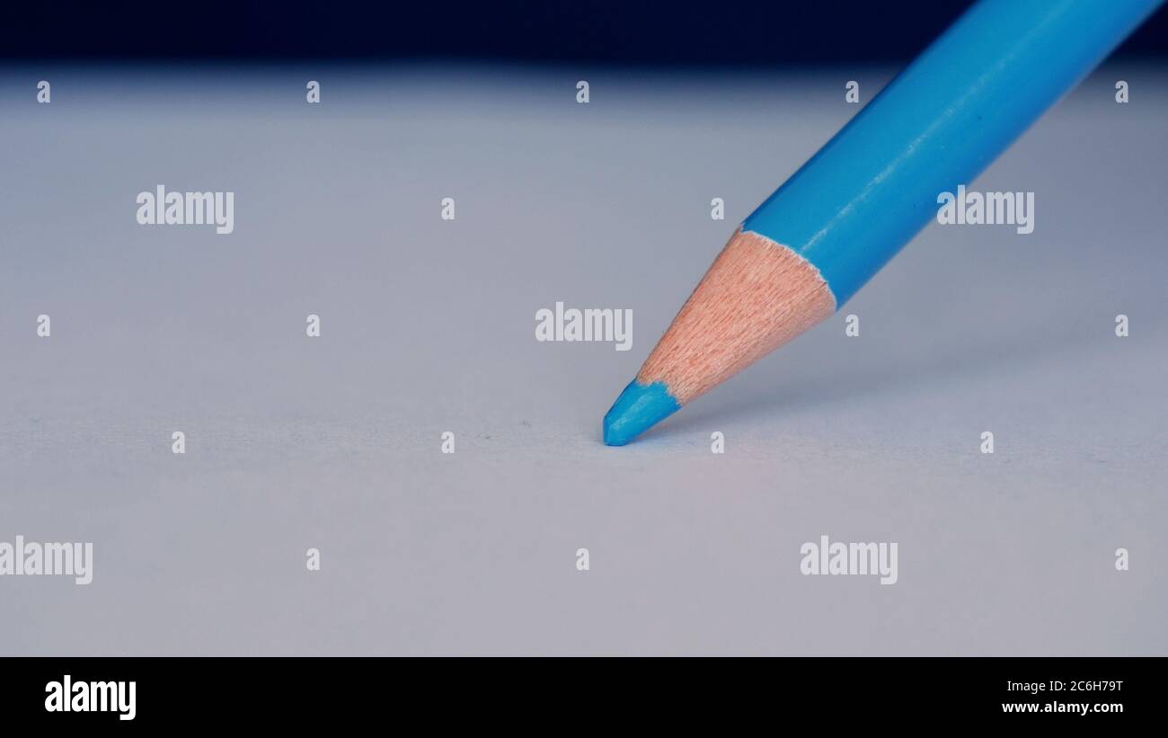 Immagine con una persona disegno con una matita colorata su un pezzo di carta bianco Foto Stock