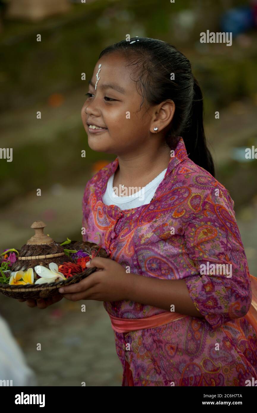 Ragazza con offerta durante Siat Sampian Coconut Leaf War festival, pura Samuan Tiga, Ubud, Bali, Indonesia Foto Stock