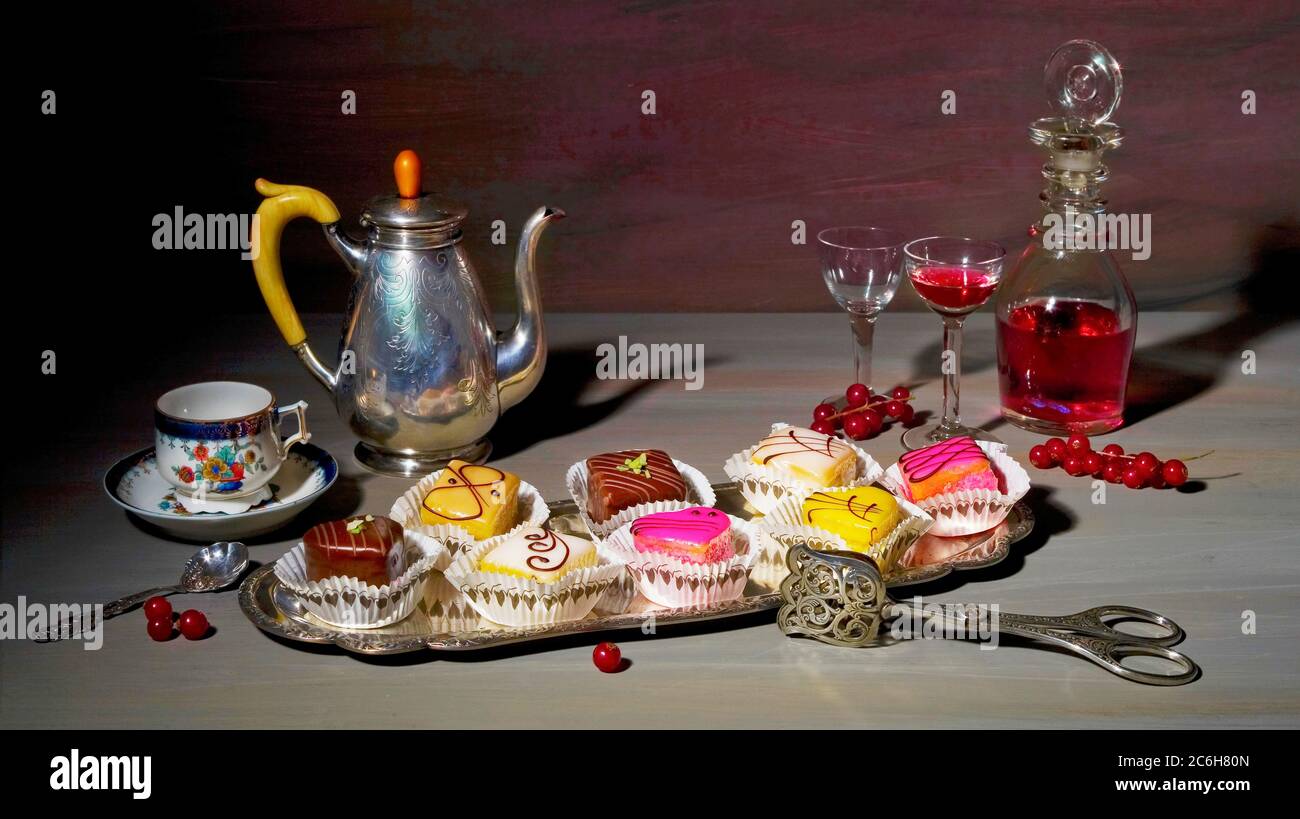 cibo in stile vintage ancora vita con nobili dolci petit four e piatti pregiati d'annata Foto Stock