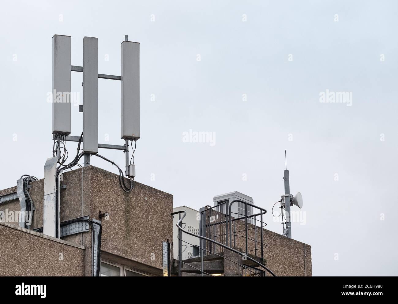 Vista isolata delle antenne di rete telefonica appena installate, vista in cima al blocco dell'ufficio. Foto Stock