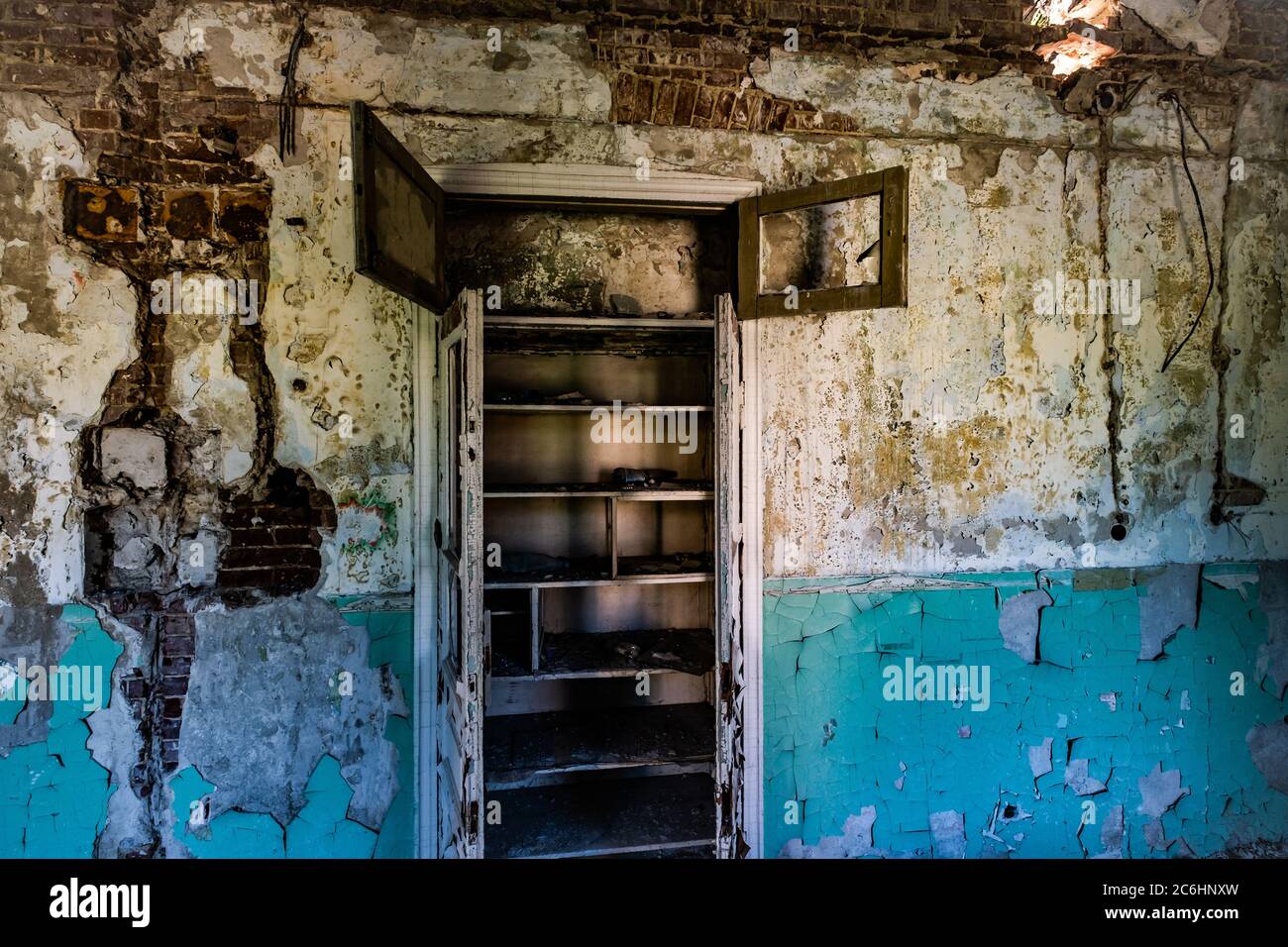 Aperto, distrutto e abbandonato armadio in legno invecchiato in una camera vuota abbandonata in rovina in ospedale Foto Stock