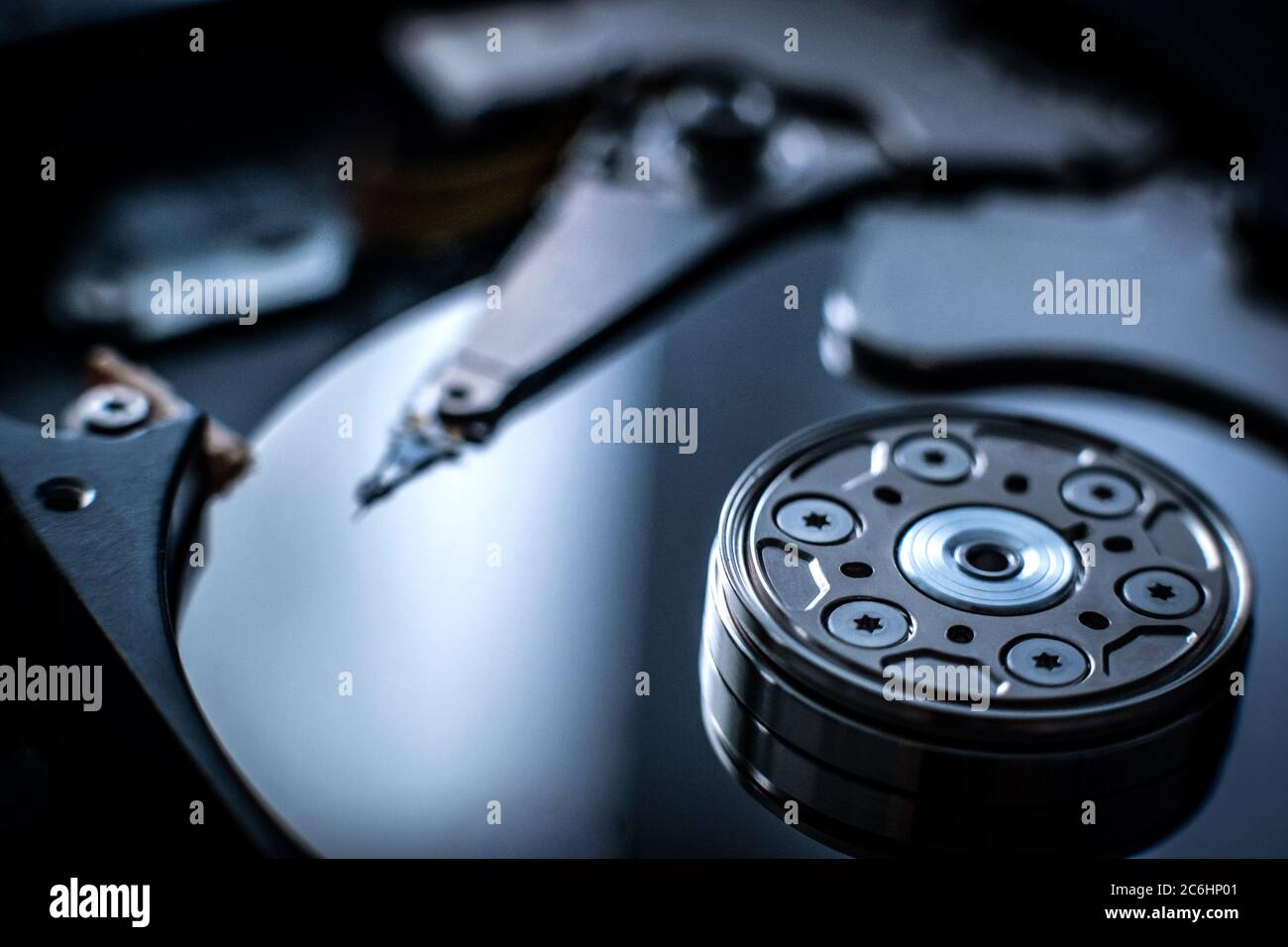 Foto macro del cilindro della testa nell'unità disco rigido su sfondo scuro sfocato Foto Stock