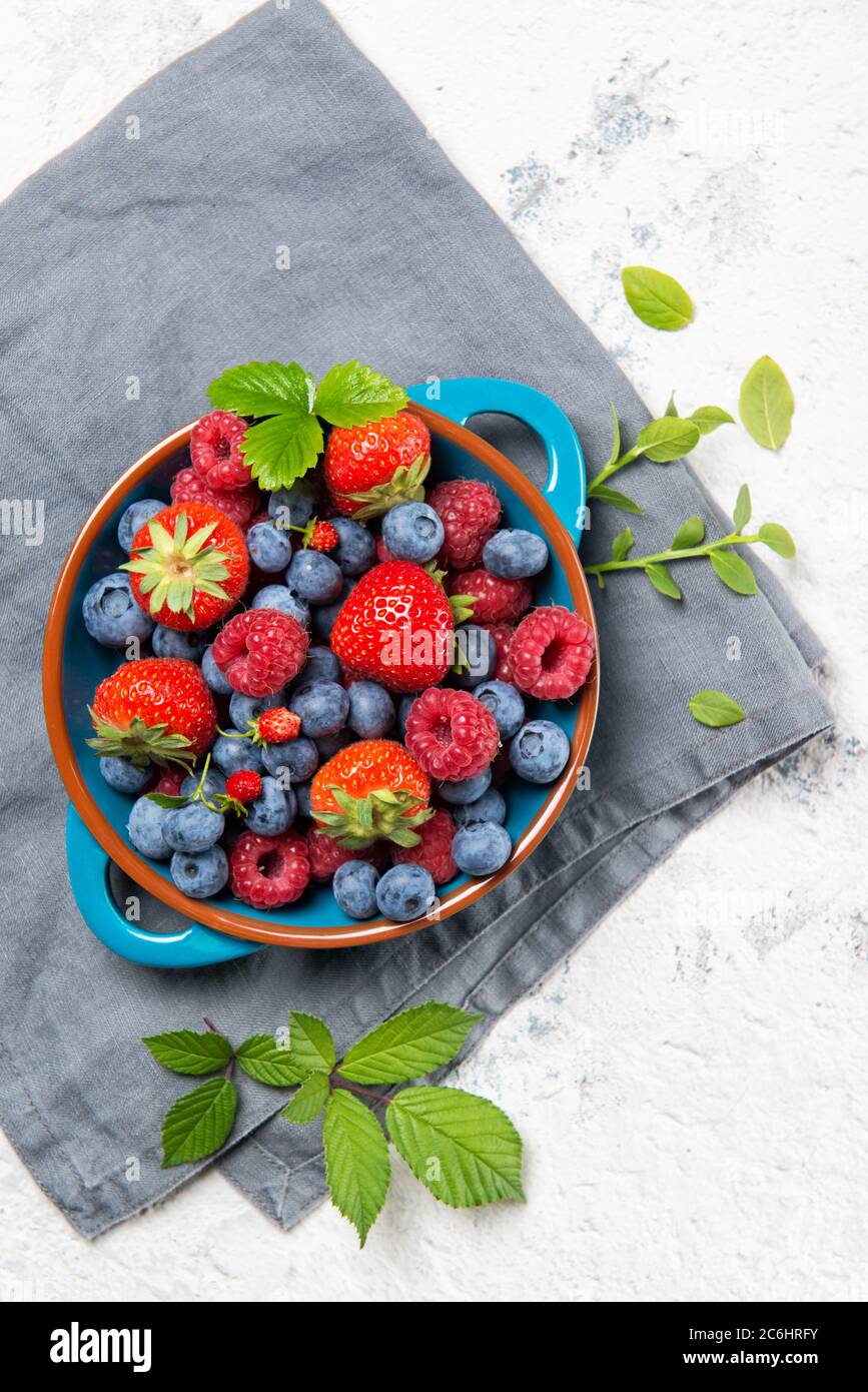 Mescolare fragola fresca, mirtillo, lamponi su un piatto su fondo di pietra, vista dall'alto Foto Stock