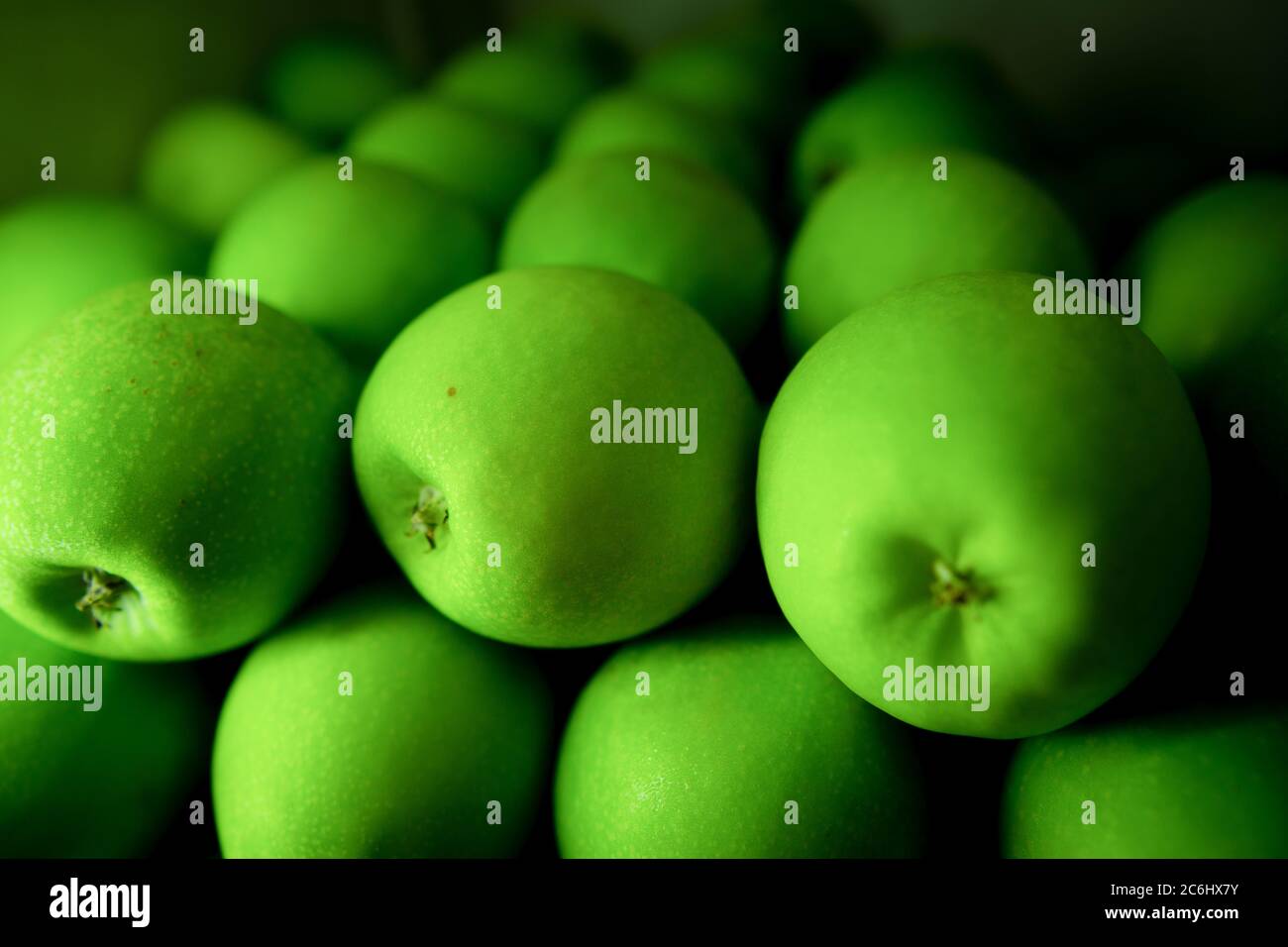 Pile perfettamente sistemate di mela verde in vendita. Le mele sono ricche di antiossidanti e aiuta a mantenere la pelle sana e perdita di peso. Foto Stock