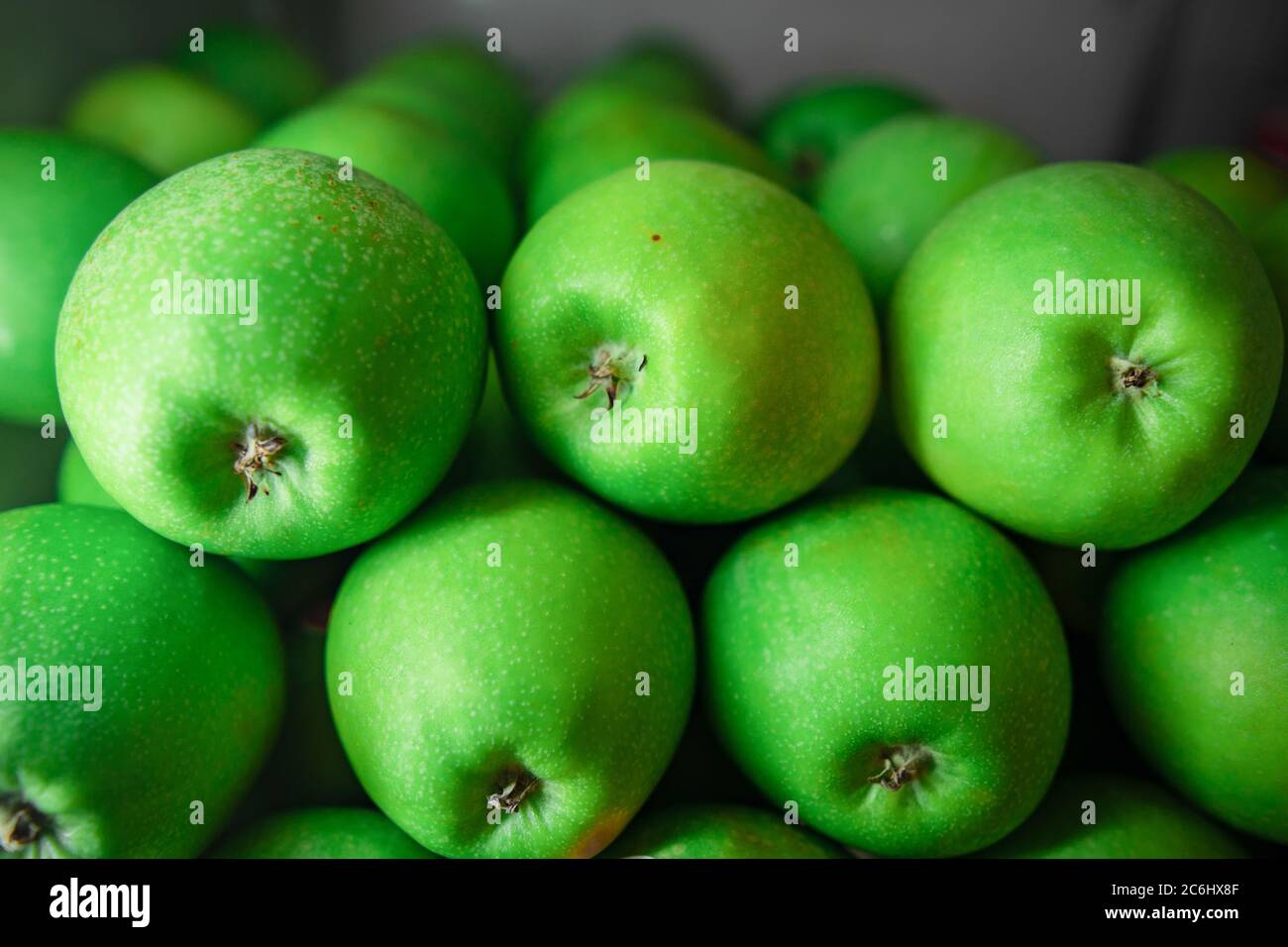 Pile perfettamente sistemate di mela verde in vendita. Le mele sono ricche di antiossidanti e aiuta a mantenere la pelle sana e perdita di peso. Foto Stock