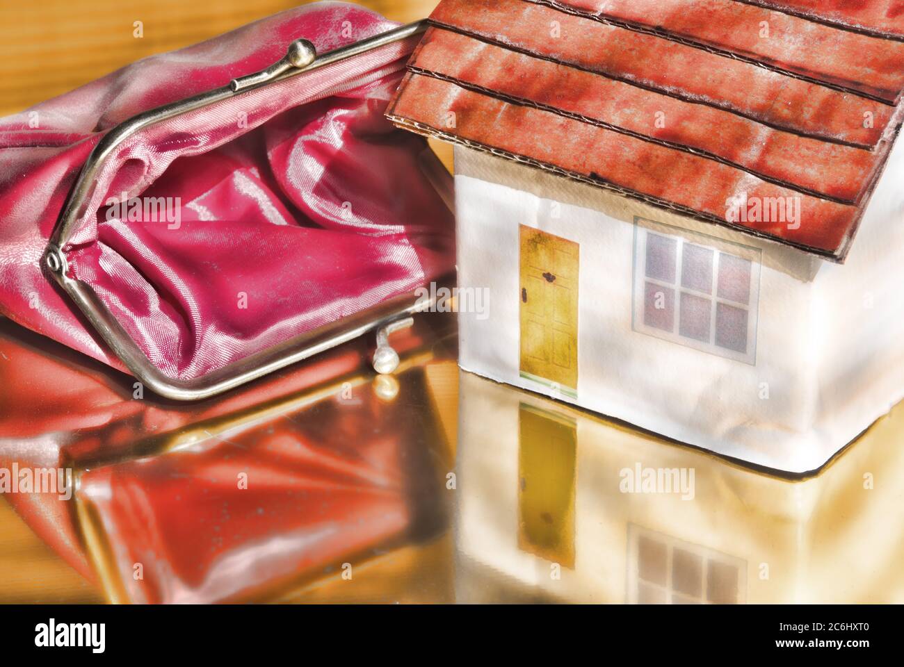 Immagine di concetto finanziario. Costo di Covid 19 a economy e risparmio. Casa giocattolo. Borsetta vuota. Idea carenza di denaro, costi di virus per gli individui. Foto Stock