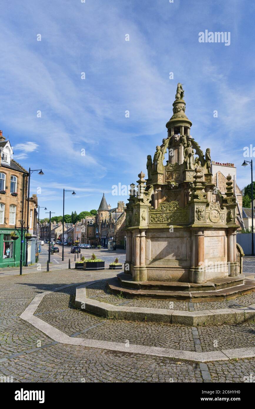 Giornata di sole e di luce che guarda ad est lungo Linlithgow High Street da Cross. Replica scolpito 1807 fontana, bene. West Lothian, Scozia centrale Regno Unito. Foto Stock