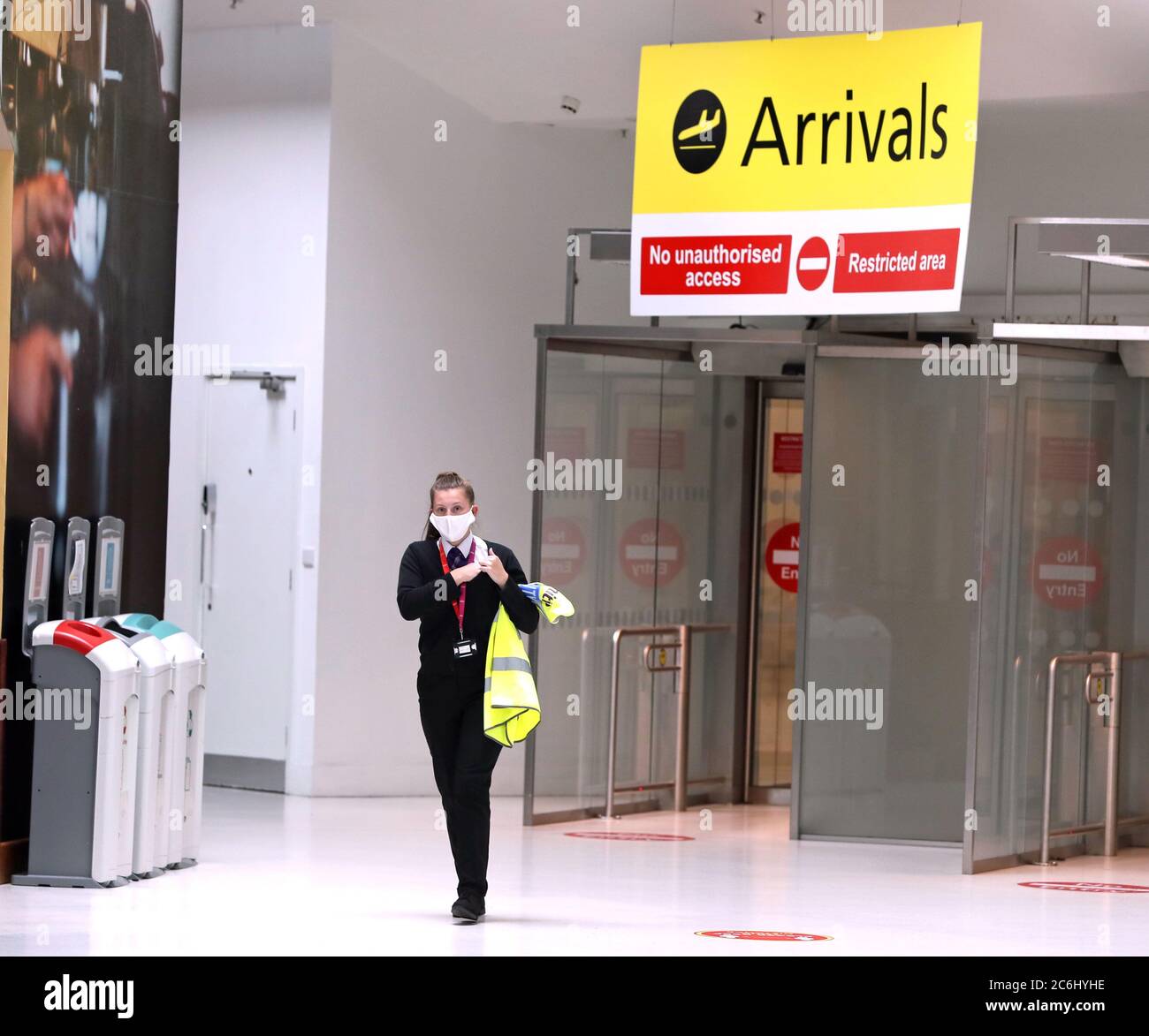 Il membro del personale degli arrivi all'aeroporto di Belfast City, nell'Irlanda del Nord, ha accettato le modifiche alle norme di viaggio e le misure di blocco. Foto Stock