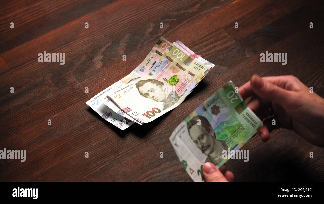 L'uomo considera i nuovi soldi della carta Ucraina. Concetto di salario vivente. Concetto di budget per famiglie. Primo piano Foto Stock