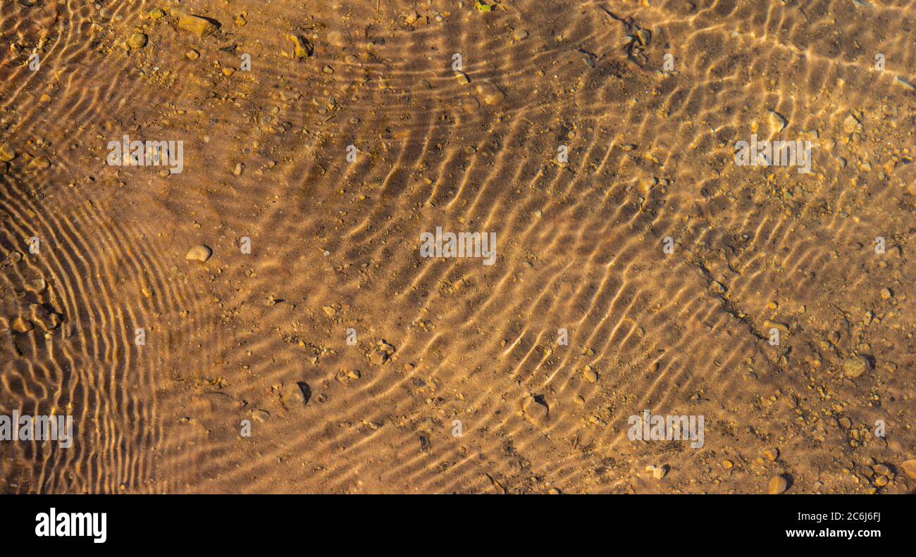acqua poco profonda che si increspa sul fondo del fiume Foto Stock