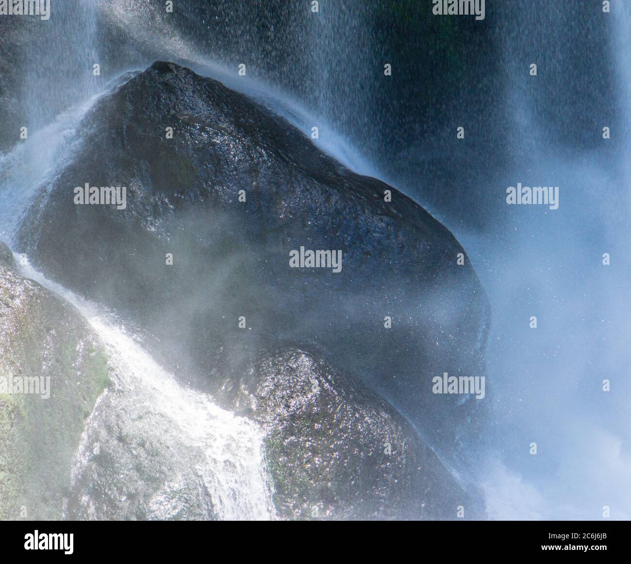 acqua misty che colpisce le rocce in una cascata Foto Stock