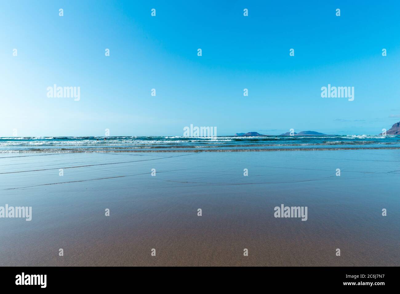 Panorama di bellissima spiaggia e mare tropicale di Lanzarote. Canarie. Costa di Famara spiaggia, Lanzarote isola, Isole Canarie. Turisti sul più pop Foto Stock