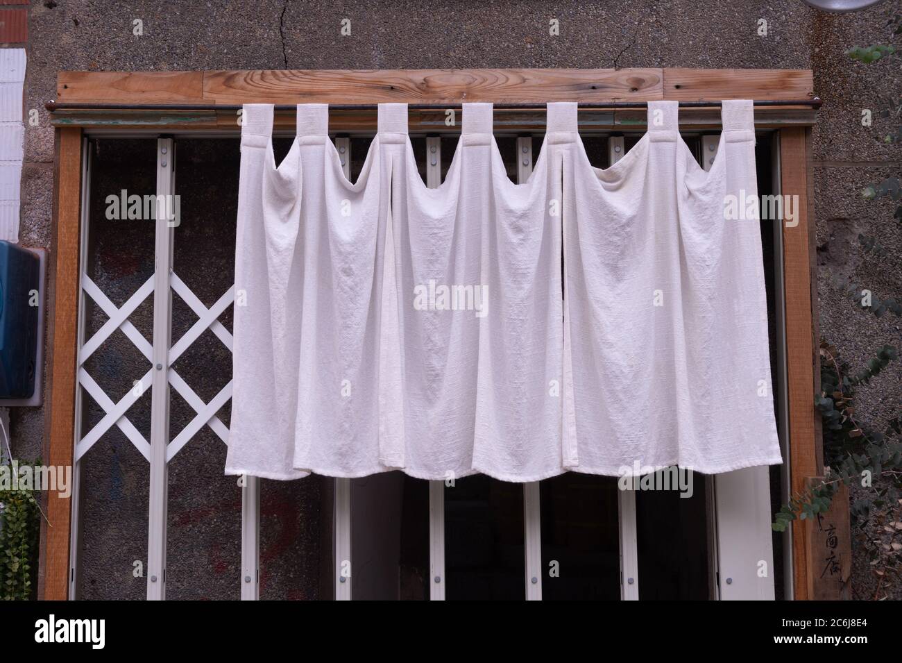 Il tessuto simile a una tenda che pende di fronte ai ristoranti e negozi tradizionali giapponesi serve non solo come un cartello, ma ha un significato più grande, Foto Stock