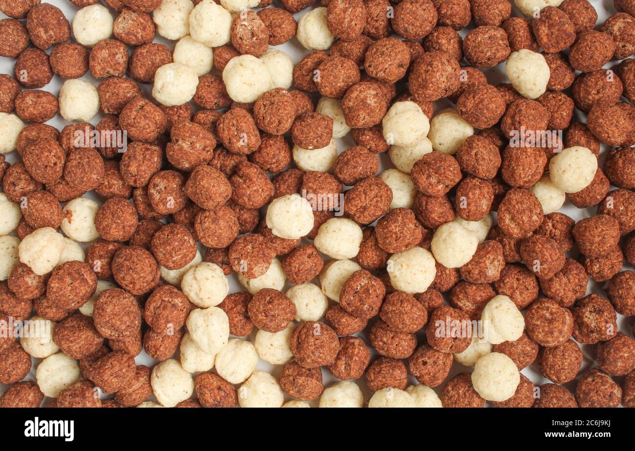 Schermo intero di deliziosi cornflakes rotondi. Cereali al cioccolato bianco e marrone misti Foto Stock