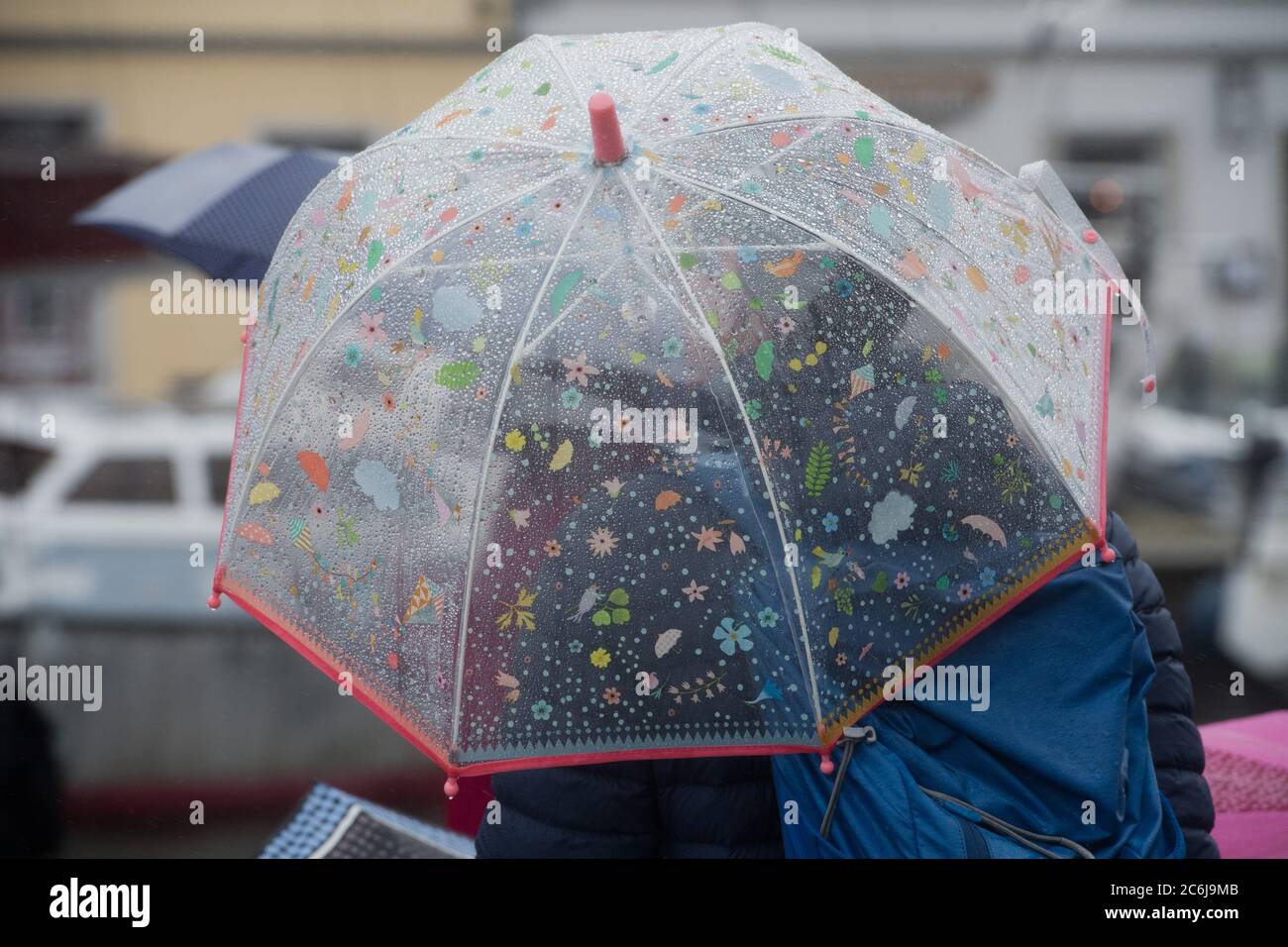 Stralsund, Germania. 10 luglio 2020. Un uomo con ombrello cammina nel porto di Stralsund. La pioggia continua determina il tempo nel Mar Baltico. Credit: Jens Büttner/dpa/Alamy Live News Foto Stock