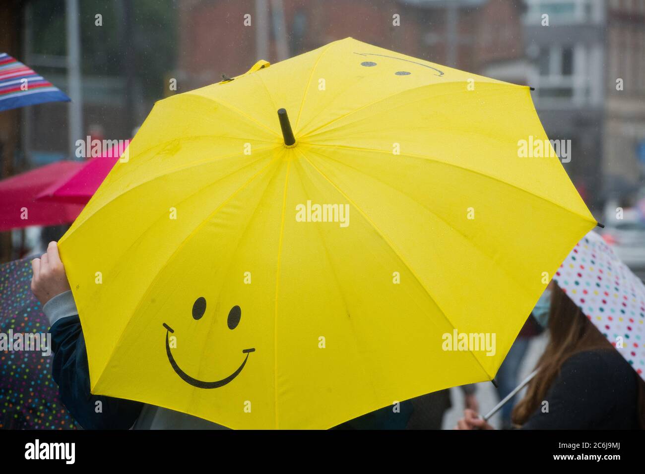 Stralsund, Germania. 10 luglio 2020. Un uomo con ombrello cammina nel porto di Stralsund. La pioggia continua determina il tempo nel Mar Baltico. Credit: Jens Büttner/dpa/Alamy Live News Foto Stock