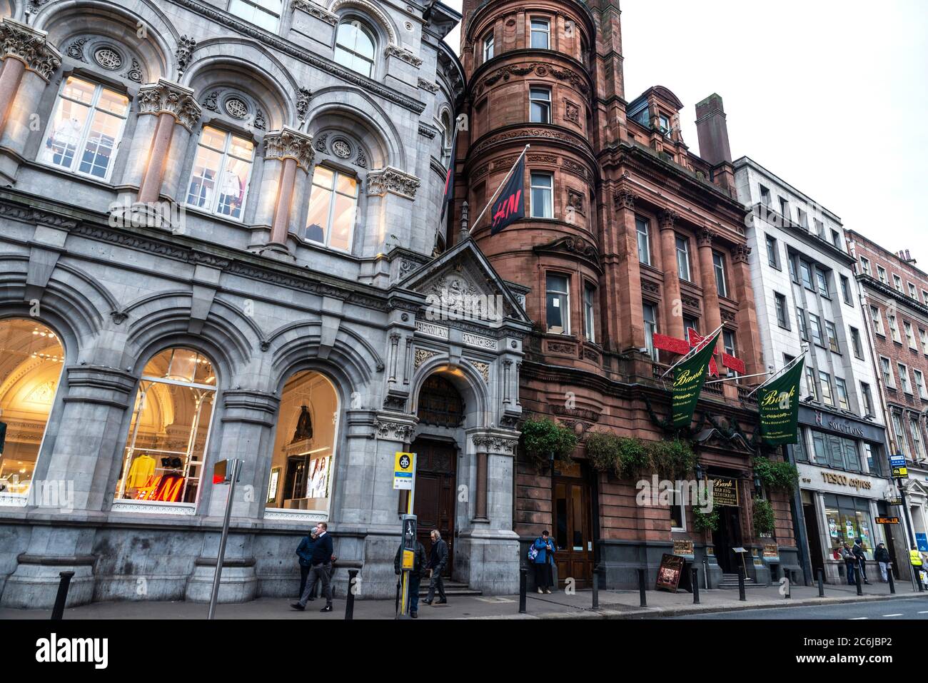 Dublino, Irlanda - 30 dicembre 2019: Dame Street con negozi, ristoranti, pub irlandese e gente intorno nel centro di Dublino, Irlanda Foto Stock