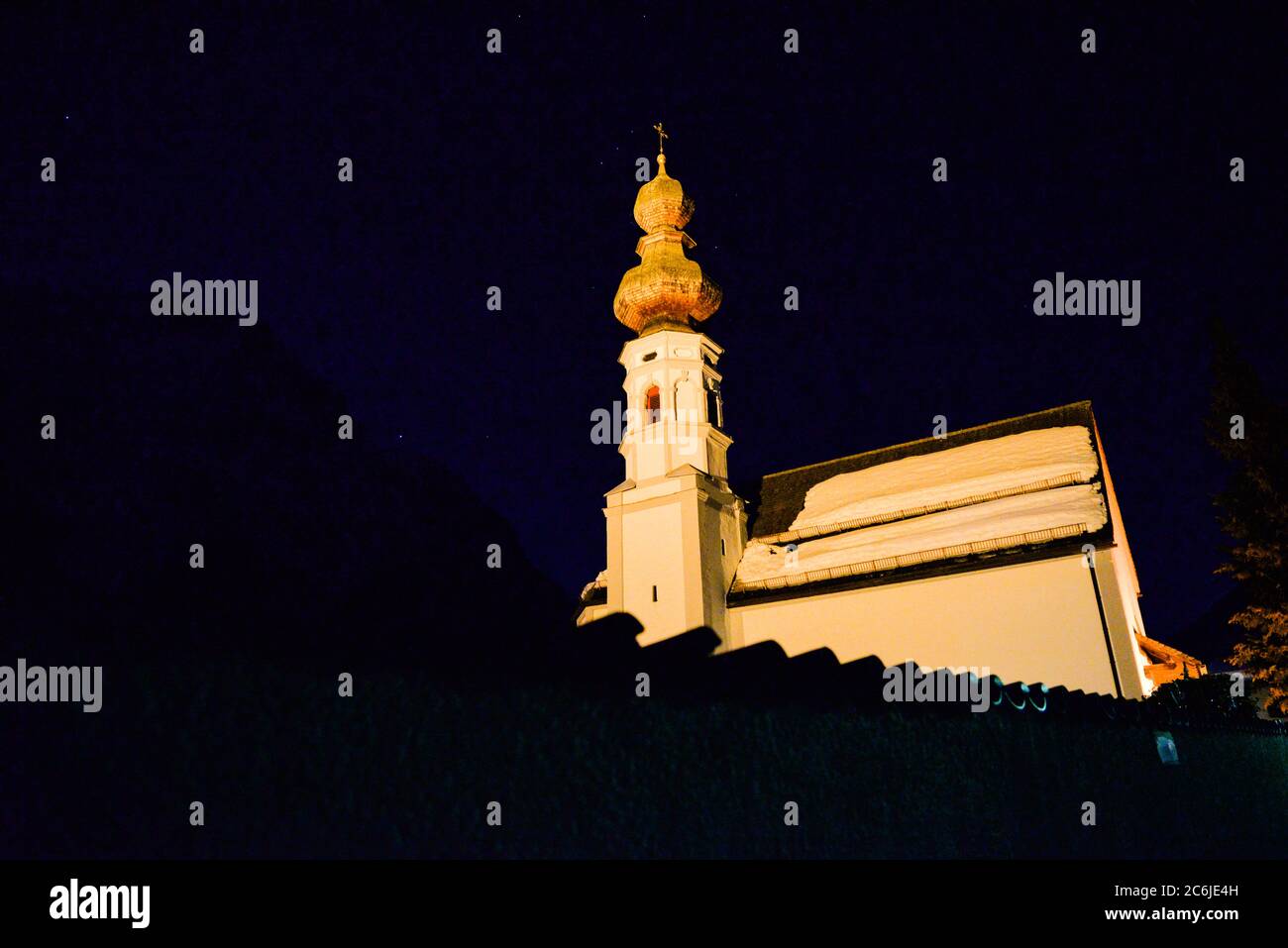 Le Alpi si profilano sopra, la notte, la chiesa di San Nicola, Mittenwald, Germania Foto Stock